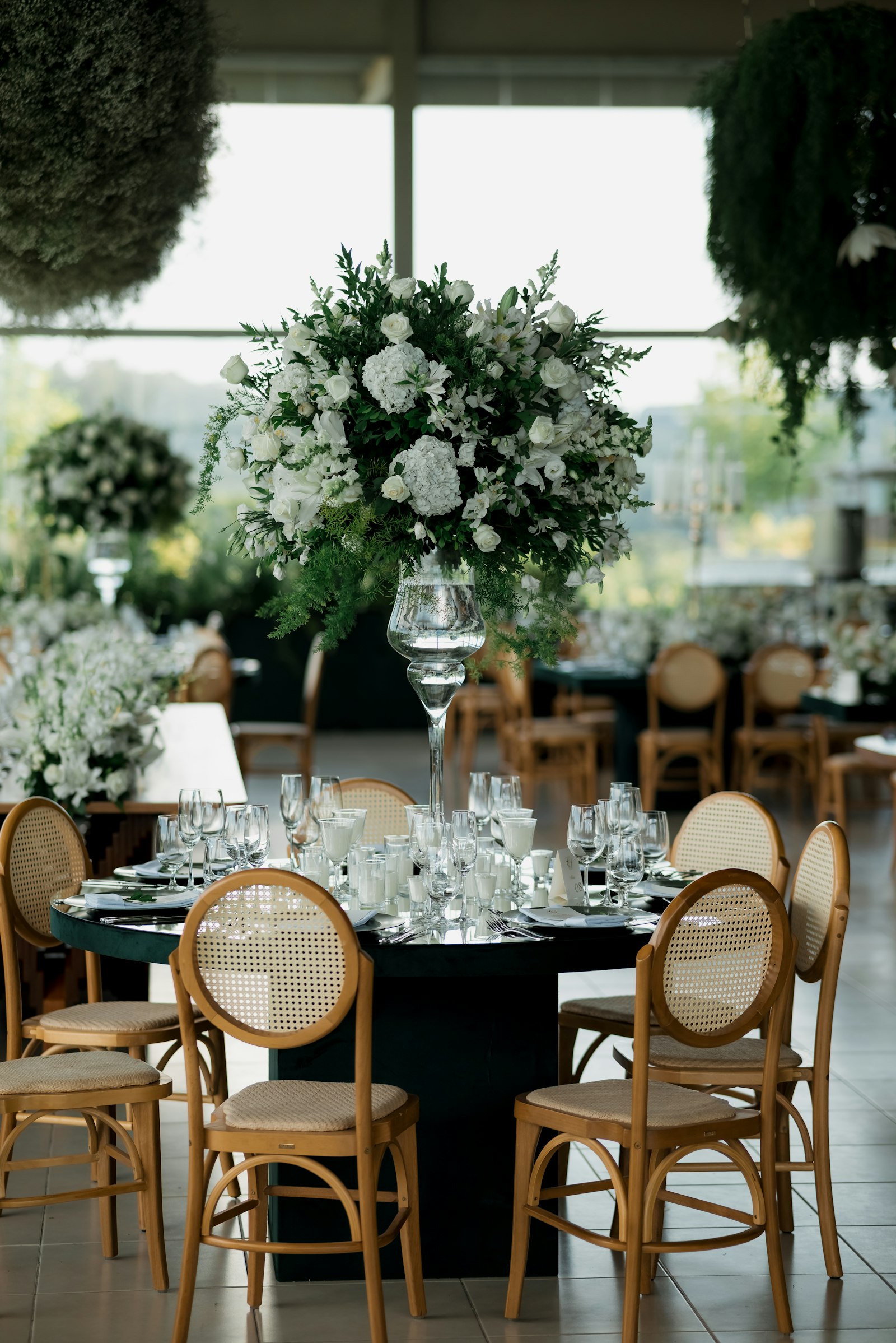 A long wedding table dressed with candles, glassware and flowers